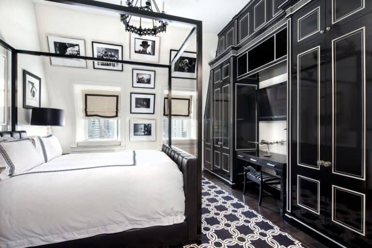 Luxurious modern bedroom interior with black and white decor, stylish furniture, and framed cityscape photos, featuring a sleek wardrobe and cozy bed for upscale living.