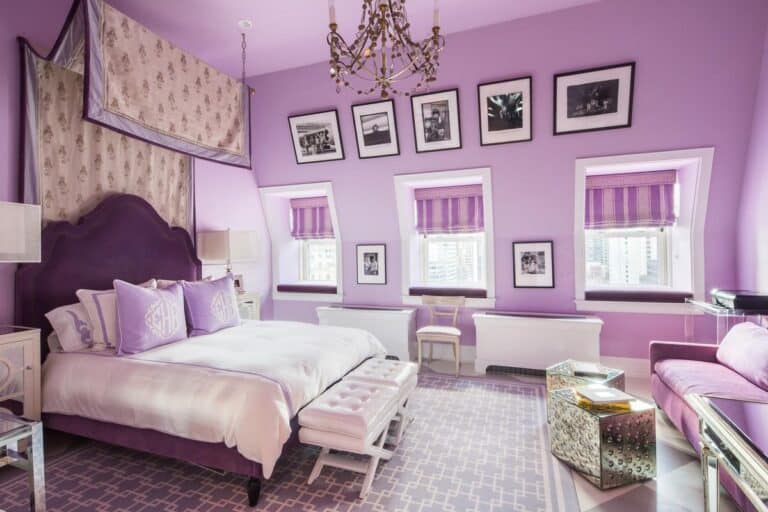 Luxurious purple bedroom decor with elegant chandelier, framed black-and-white photos, and modern furniture for a sophisticated living space.