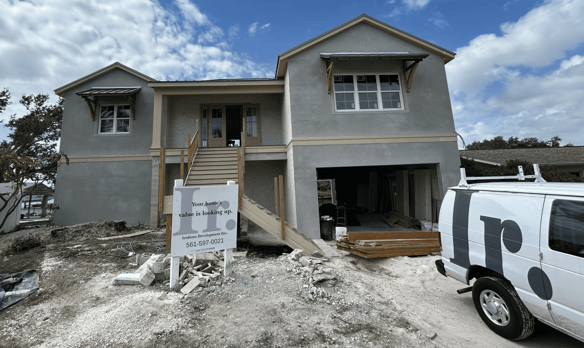 Construction of a new residential home by Iridium Development Inc. showcases modern building expertise, with the house in early stages of development and a branded van on-site.