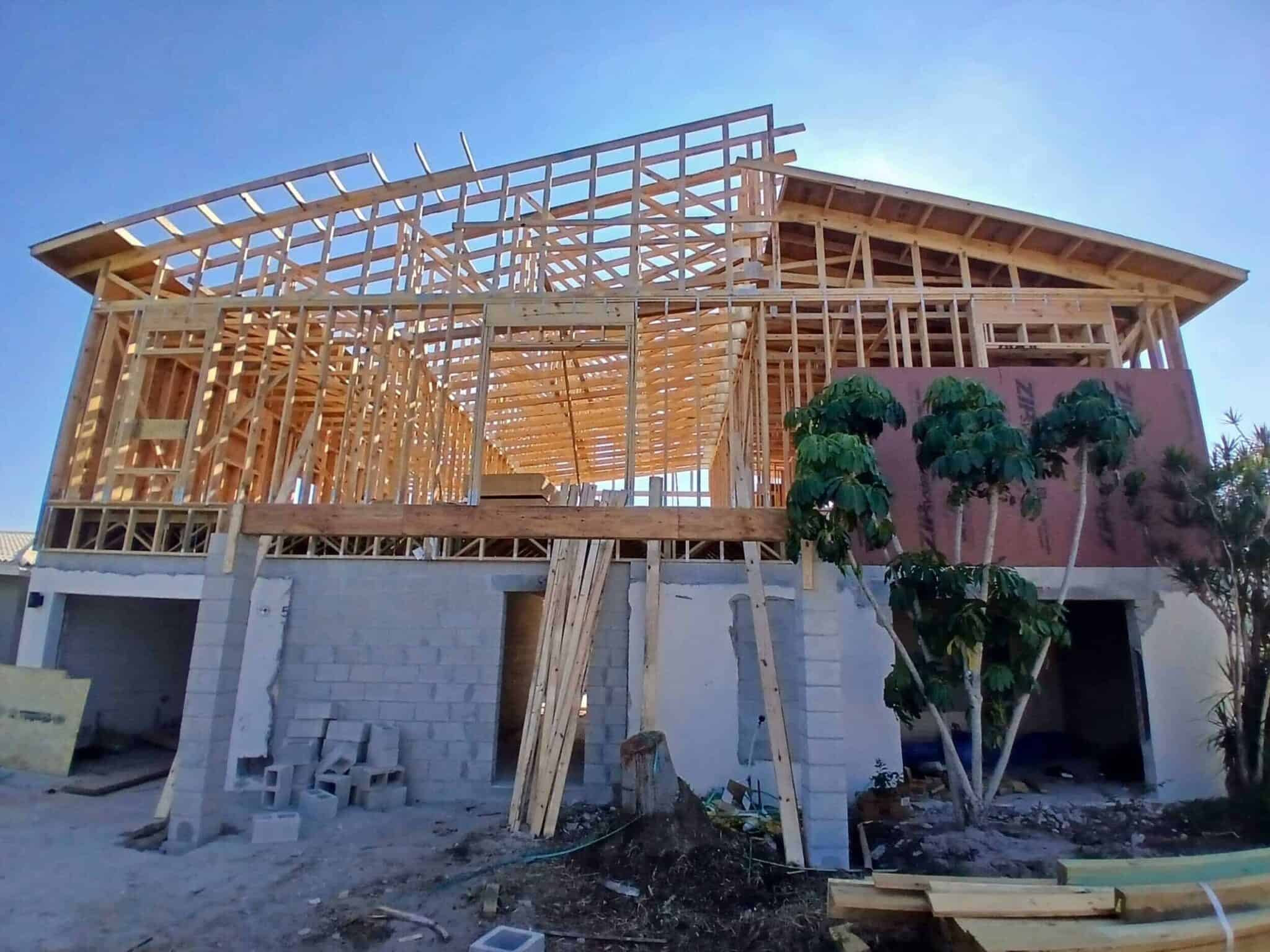 High-quality image of a house under construction, focusing on the wooden framing and structural development, ideal for real estate or construction projects.