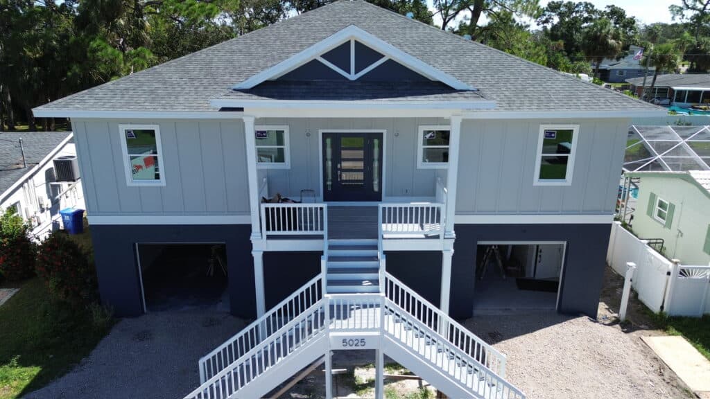 A beautiful elevated coastal home featuring modern architectural elements, durable materials, and a spacious balcony. Perfect for waterfront living, showcasing contemporary design and quality craftsmanship.